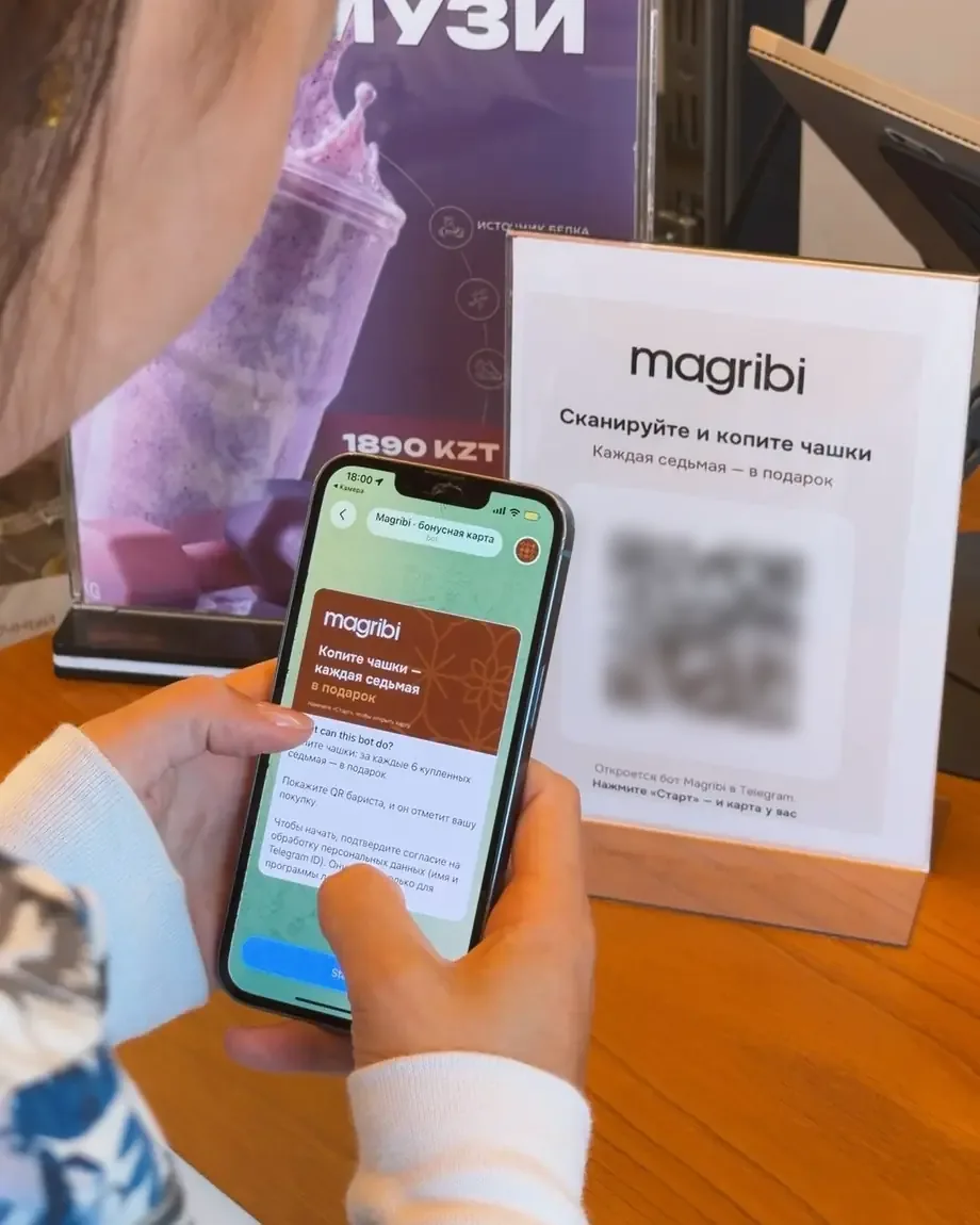 Гостья Magribi сканирует QR на постере у кассы, в телефоне открылся бот кофейни